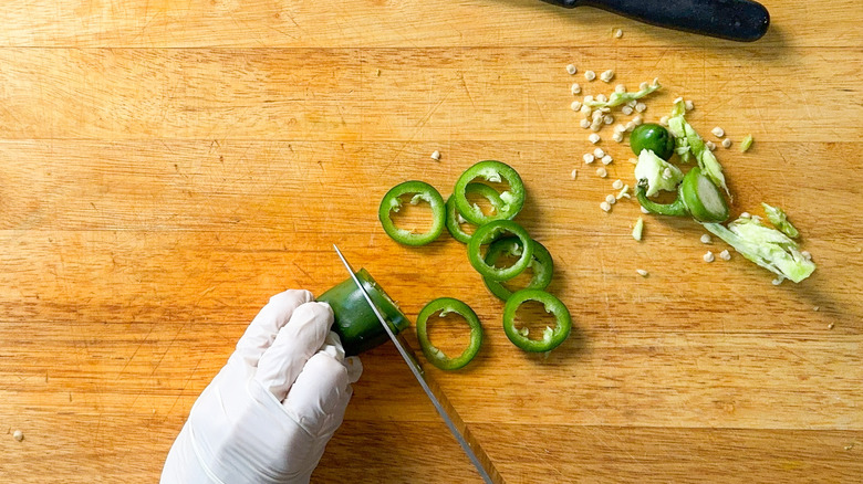 Slicing jalape&ntilde;o rings using latex gloves on cutting board